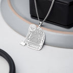 Silver firefighter uniform pendant necklace displayed beside dark jewelry. (PG102878, secondary photo 5)