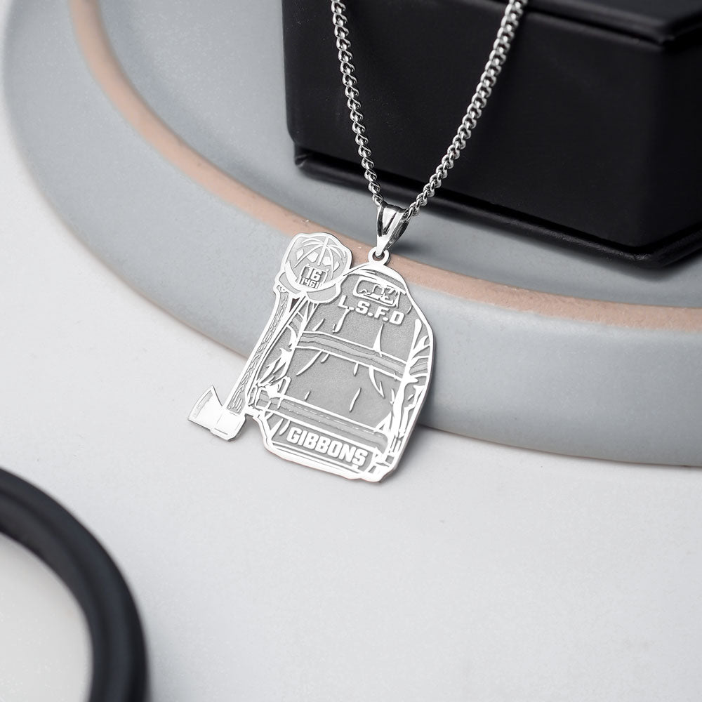 Silver firefighter uniform pendant necklace displayed beside dark jewelry. (PG102878, secondary photo 5)