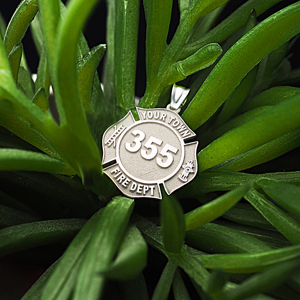 Firefighter badge pendant photographed among green leaves. (PG71196, secondary photo 6)