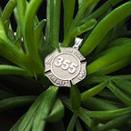 Firefighter badge pendant photographed among green leaves. (PG71196, secondary photo 6)