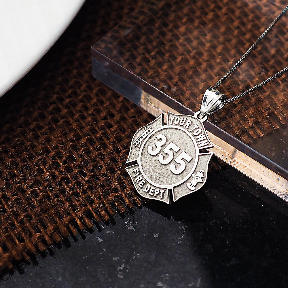 Firefighter badge pendant photographed against a dark textured background. (PG71196, secondary photo 8)