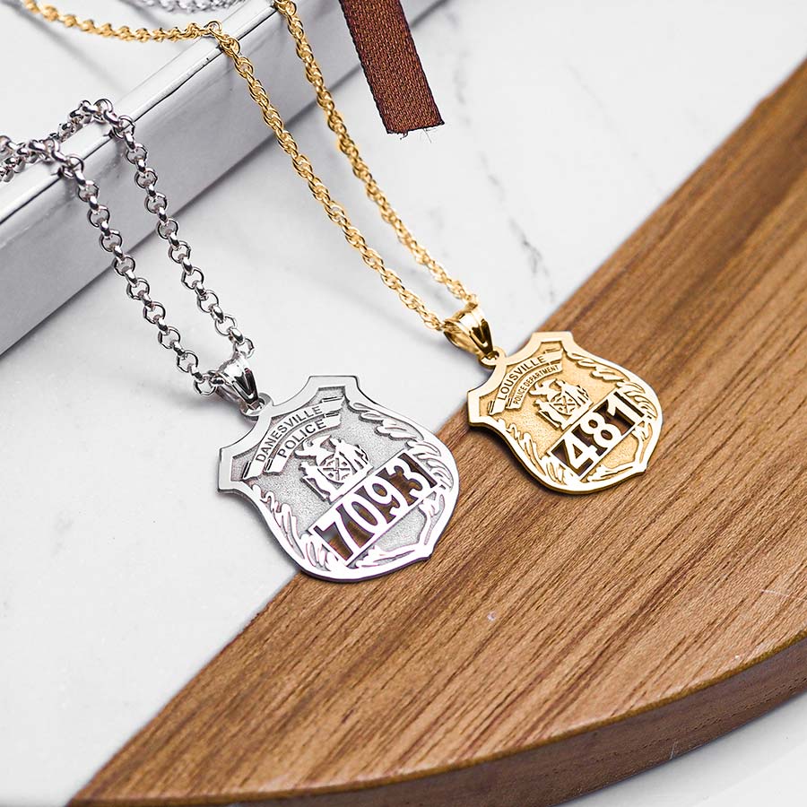Personalized police badges — silver and yellow gold beside book